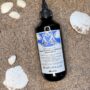 Davines Naturaltech Rebalancing Cleansing Treatment 250 ml, intensiv rensebehandling for fet hodebunn, flaske på sand med skjell – Nalu Nalu Frisør