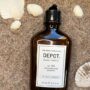 Depot No. 105 Invigorating Shampoo 250 ml i brun glassflaske på sand med skjell – Nalu Nalu Frisør